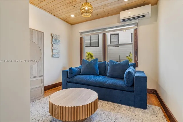 a bedroom with a bed a tv and wooden floor