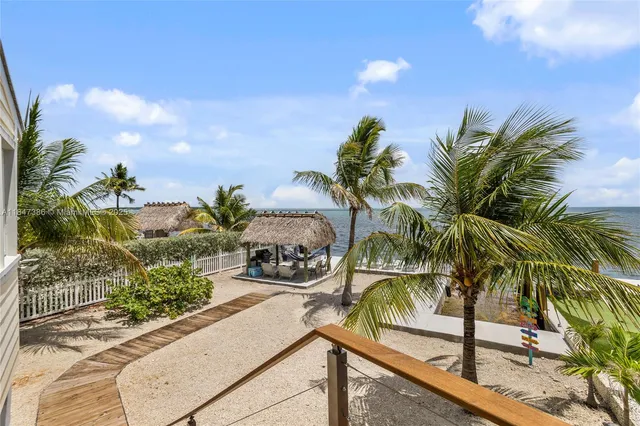 a front view of a house with a yard and potted plants