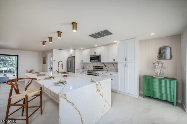 a kitchen with stainless steel appliances kitchen island granite countertop a sink and cabinets