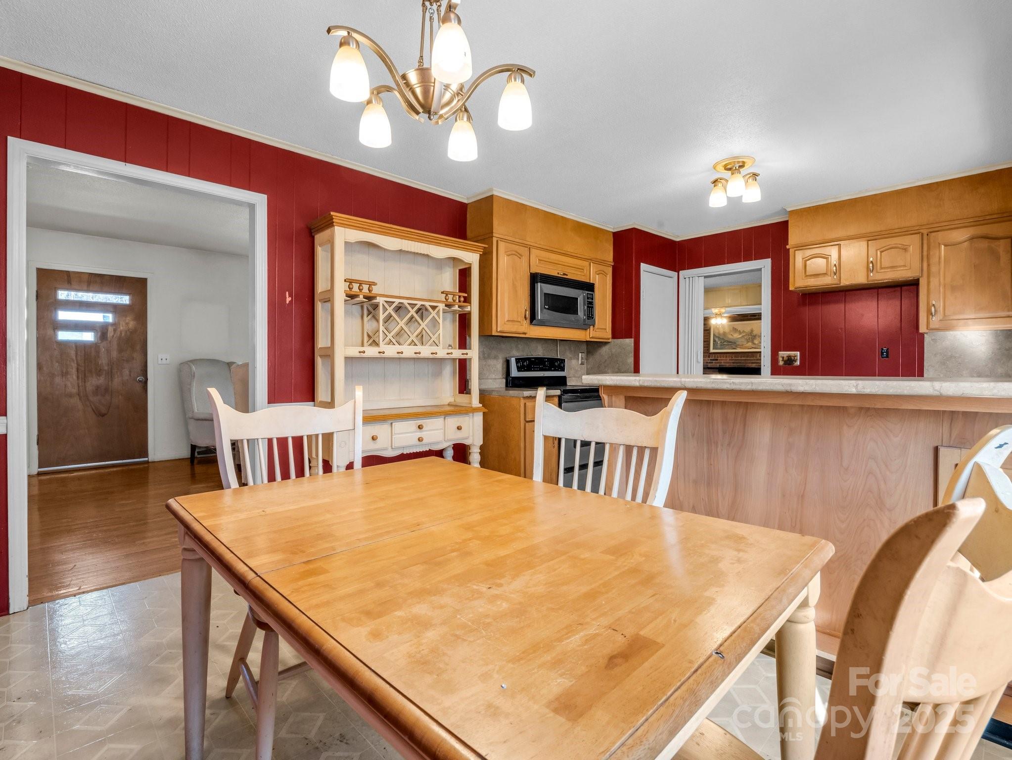 127 Mapp Street Spindale, NC 28160 - Photo 15 of 32 a kitchen with stainless steel appliances granite countertop a stove top oven a sink a dining table and chairs with wooden floor