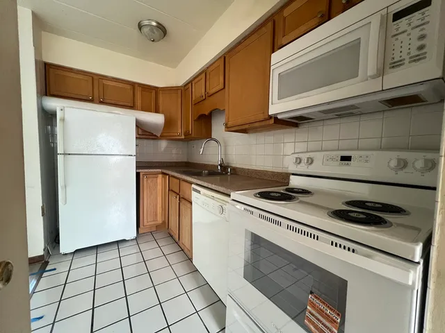 a kitchen with a stove cabinets and a refrigerator
