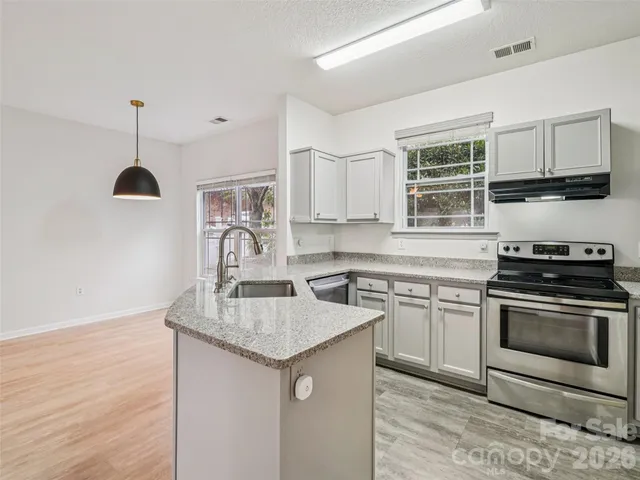 a kitchen with stainless steel appliances granite countertop a sink stove and cabinets