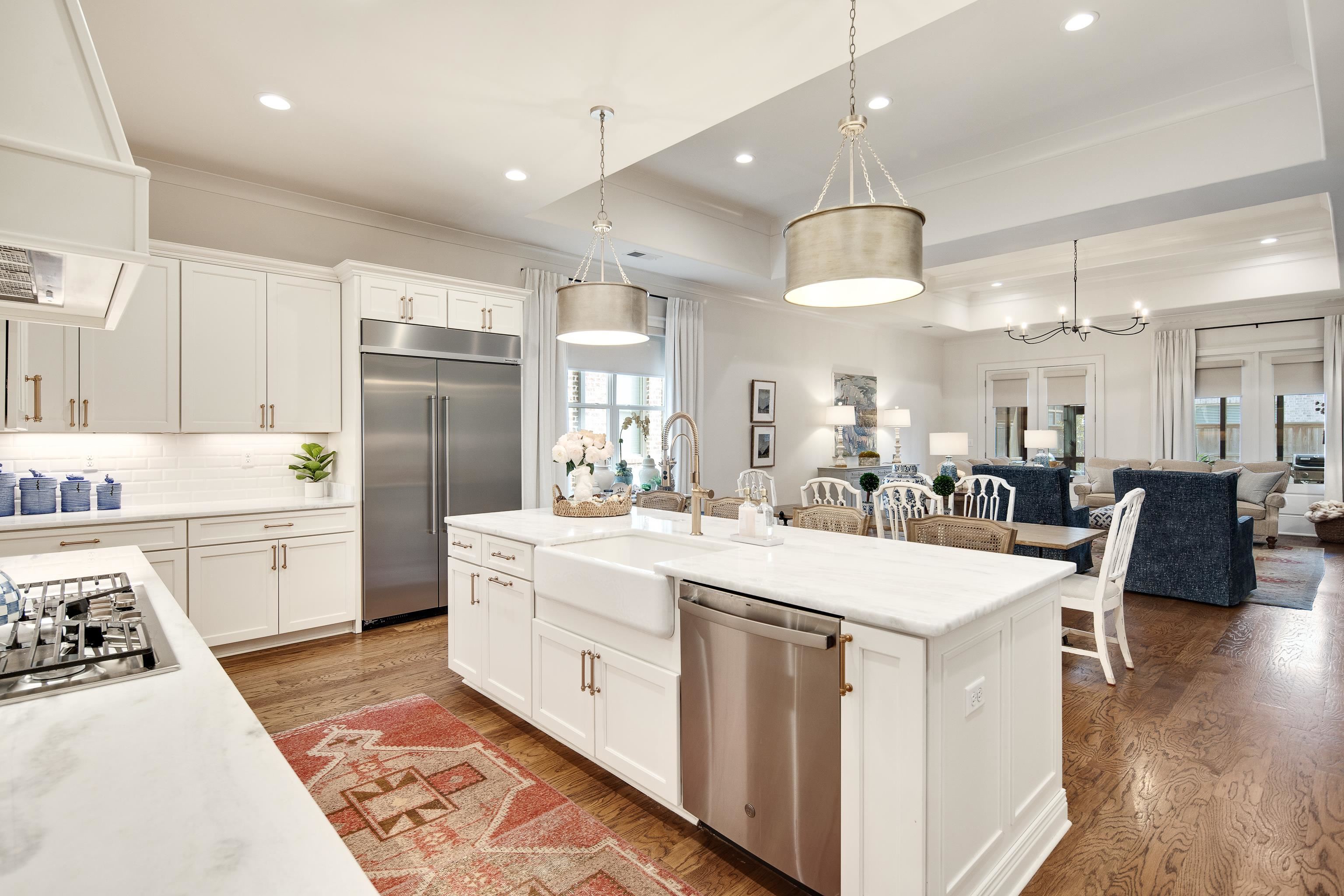 1389 Peyton Parkway Collierville, TN 38017 - Photo 6 of 38 a large white kitchen with a white countertops a stove a dining table and chairs