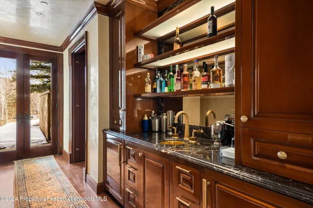 a bathroom with a granite countertop sink a mirror and shower
