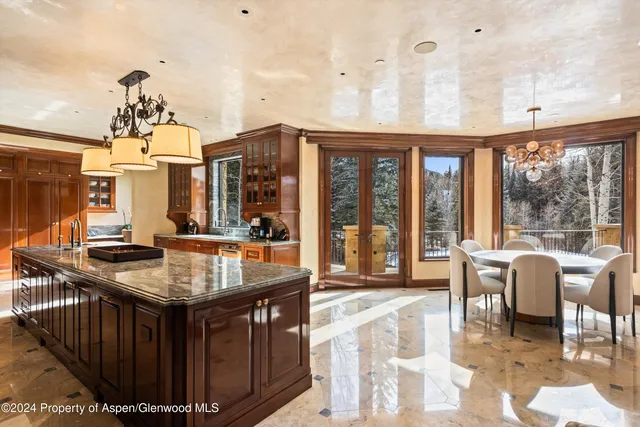 a view of a livingroom with furniture a chandelier and wooden floor