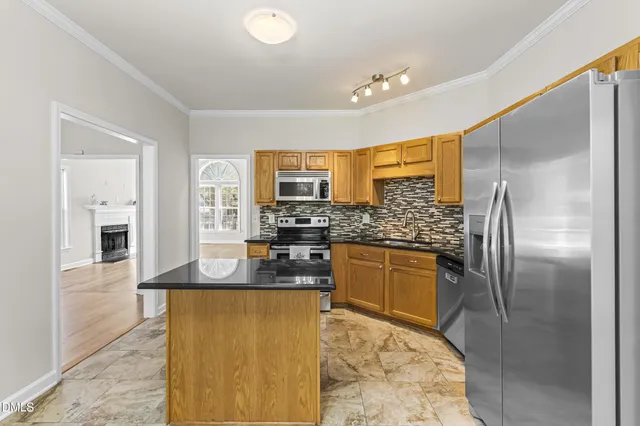 a kitchen with stainless steel appliances granite countertop a sink refrigerator and cabinets