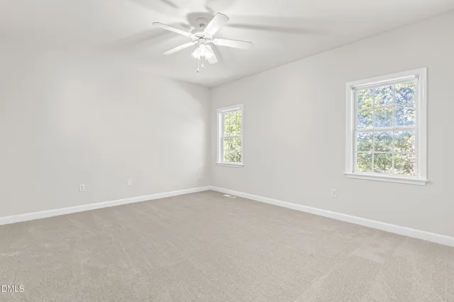 an empty room with a window and a fan