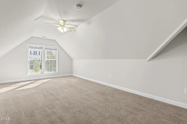 an empty room with windows and chandelier fan