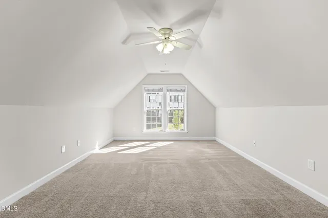 an empty room with windows and chandelier fan
