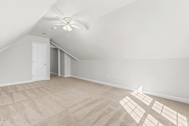 en empty room with windows and ceiling fan
