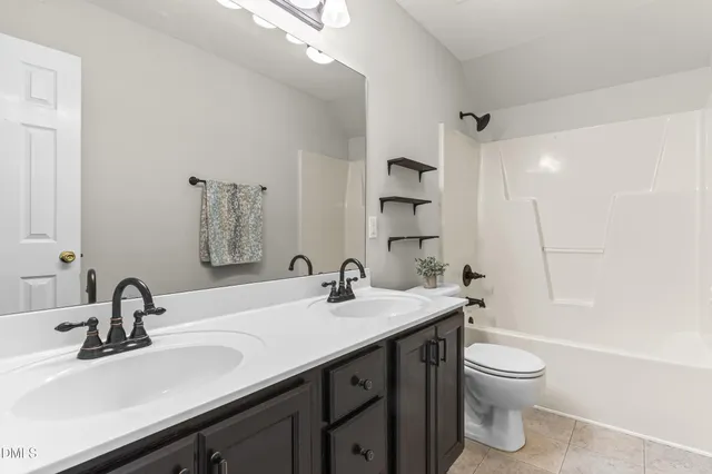 a bathroom with a double vanity sink toilet and shower