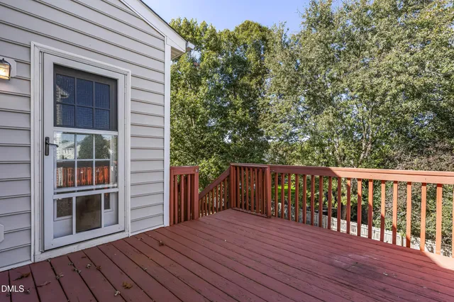 a balcony with wooden floor and yard in the back