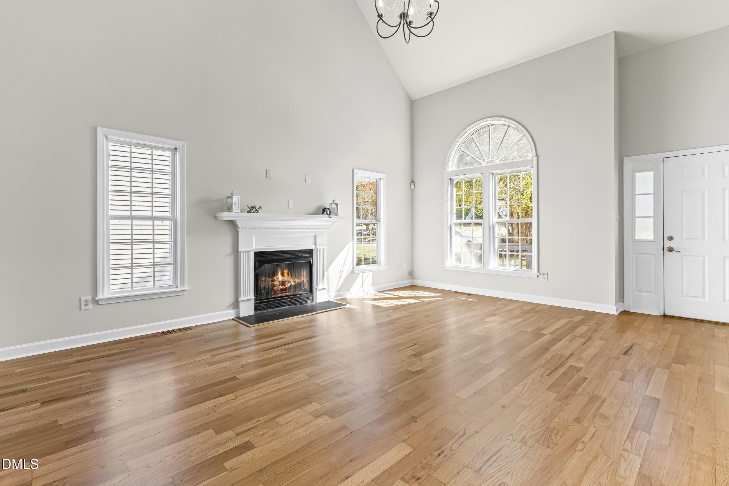 4809 Elmhurst Ridge Court Raleigh, NC 27616 - Photo 9 of 46 an empty room with wooden floor a fireplace and windows