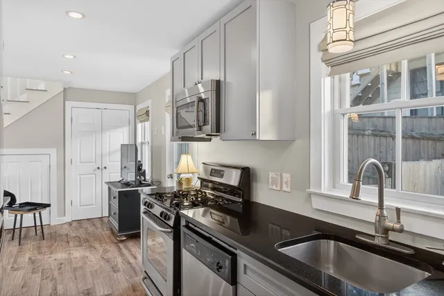 a kitchen with stainless steel appliances granite countertop a sink stove and refrigerator