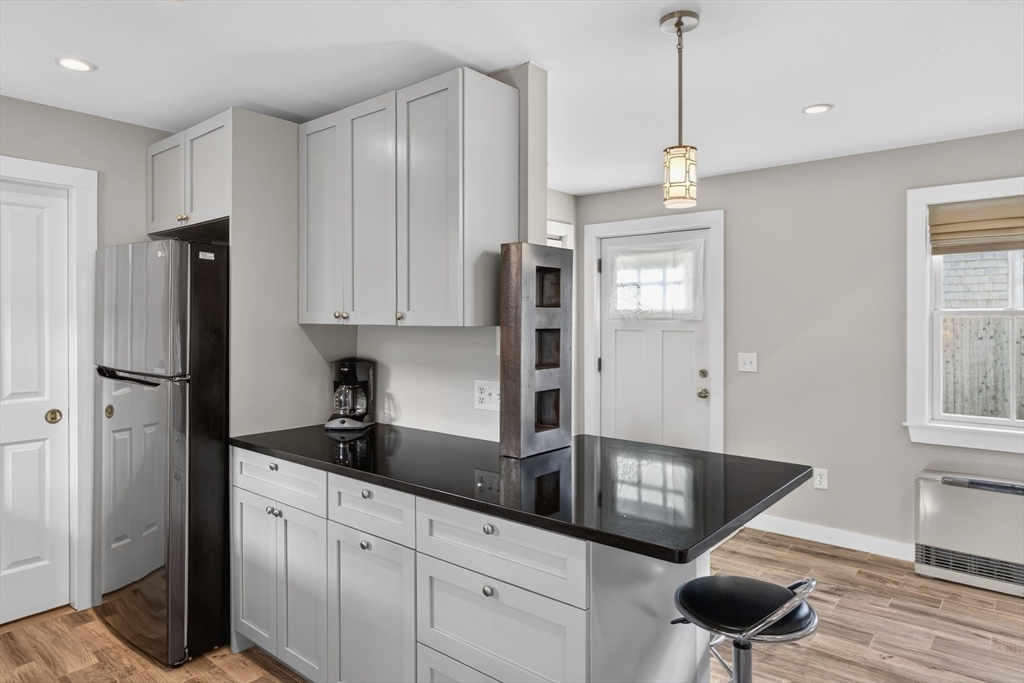 16 Conwell Street, Unit 3 Provincetown, MA 02657 - Photo 15 of 41 a kitchen with stainless steel appliances granite countertop a refrigerator a sink and a stove