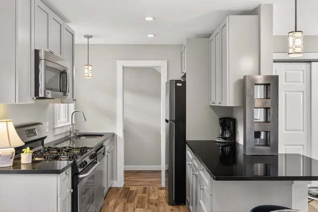 a kitchen with granite countertop a sink stove and refrigerator