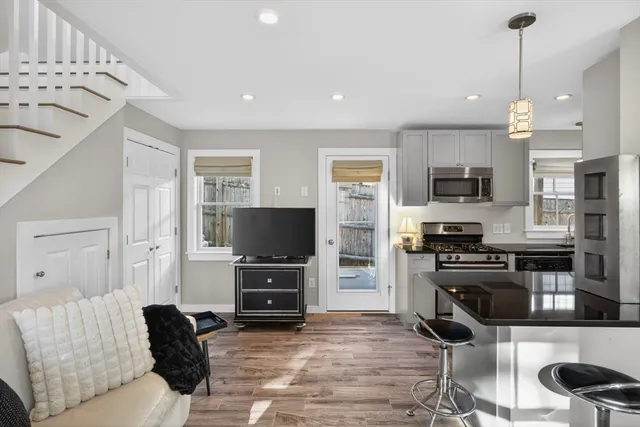 a living room with furniture a flat screen tv and kitchen view