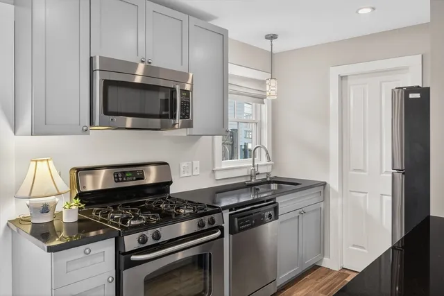 a kitchen with stainless steel appliances granite countertop a stove and a microwave