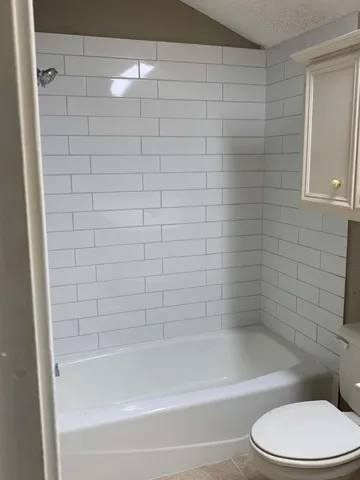 a bathroom with a toilet and bathtub
