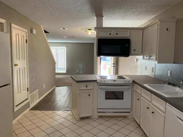 a kitchen with stainless steel appliances kitchen island granite countertop a sink and a stove