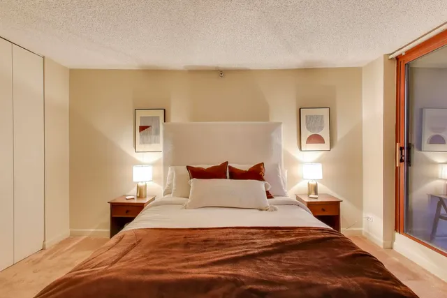 a bedroom with a bed and a night stand