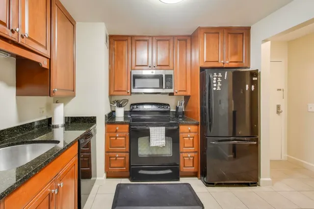 a kitchen with granite countertop a refrigerator stove and microwave