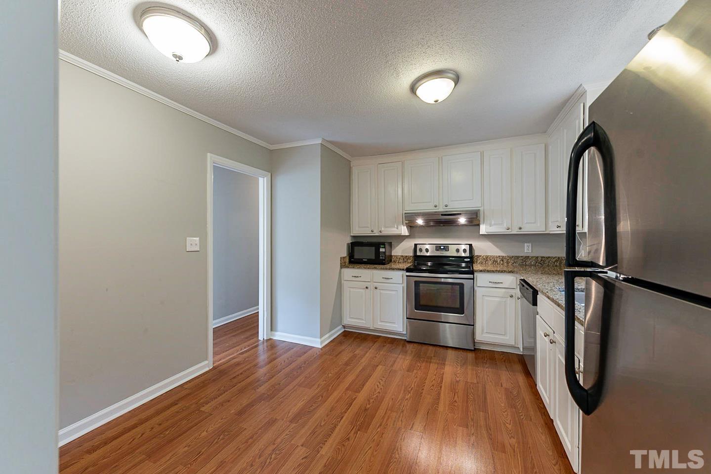 3601 Dixon Road Durham, NC 27707 - Photo 11 of 27 a kitchen with wooden floors and white appliances