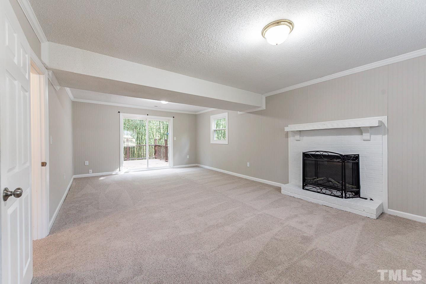 3601 Dixon Road Durham, NC 27707 - Photo 16 of 27 an empty room with a fireplace and windows