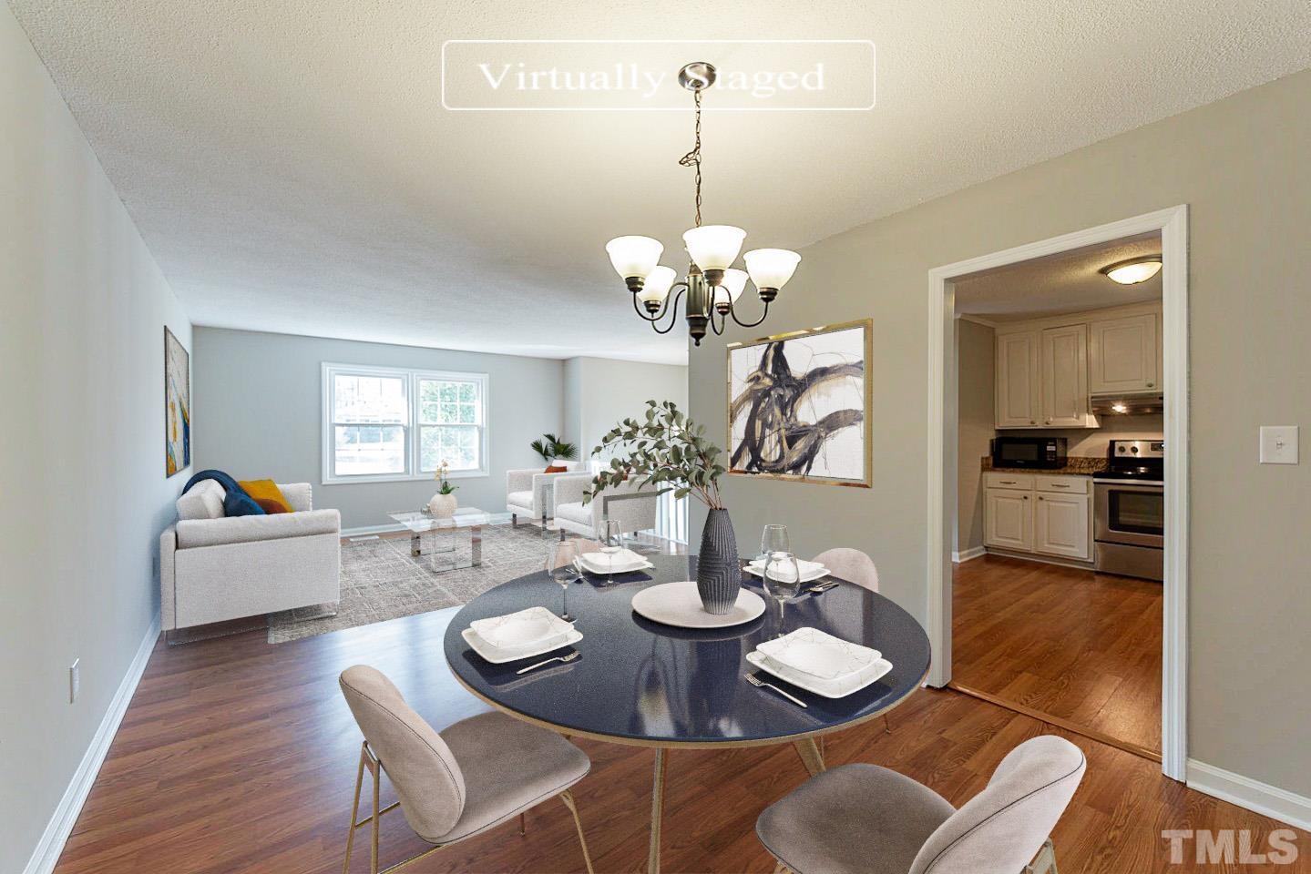 3601 Dixon Road Durham, NC 27707 - Photo 2 of 27 a dining room with wooden floor a chandelier a wooden table and chairs