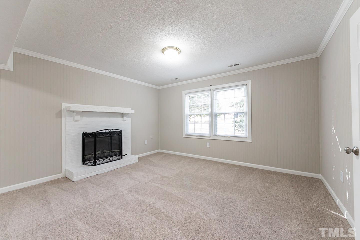 3601 Dixon Road Durham, NC 27707 - Photo 5 of 27 an empty room with a fireplace and windows
