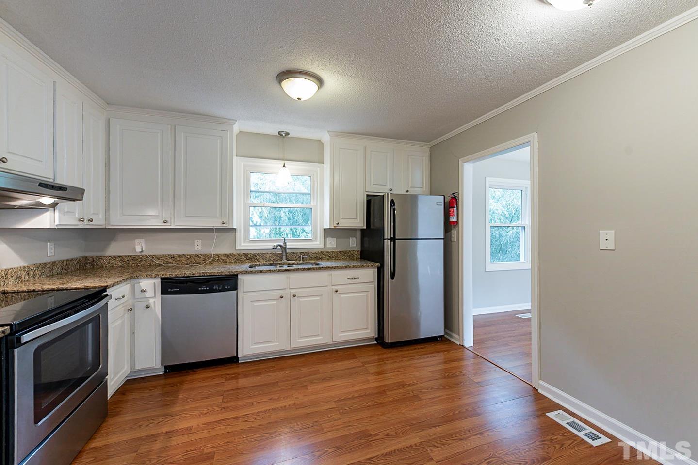 3601 Dixon Road Durham, NC 27707 - Photo 10 of 27 a kitchen with granite countertop a refrigerator stove top oven and sink
