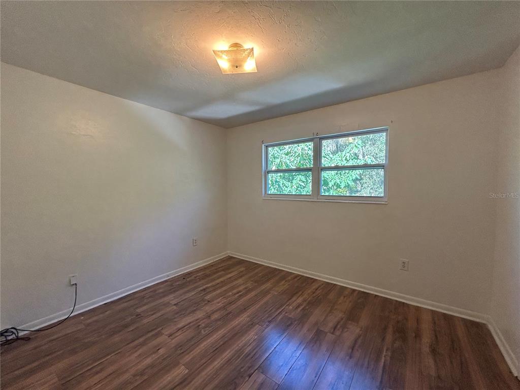 2614 Southwest 31 Place Gainesville, FL 32608 - Photo 12 of 15 wooden floor in an empty room with a window