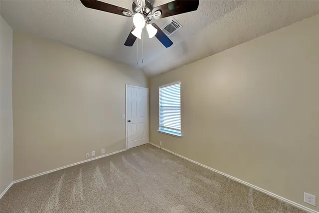 an empty room with a window and a fan