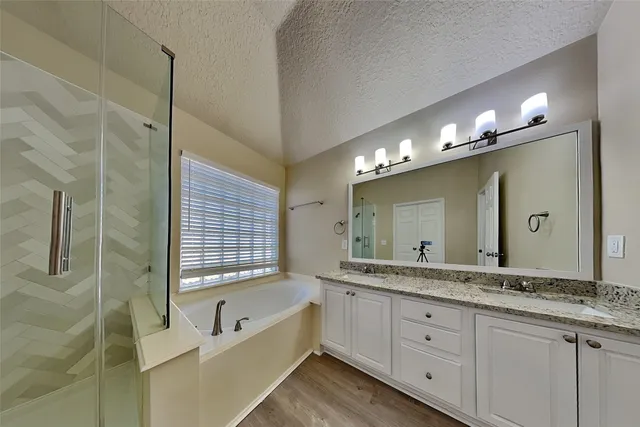 a spacious bathroom with a granite countertop sink mirror and a bath tub