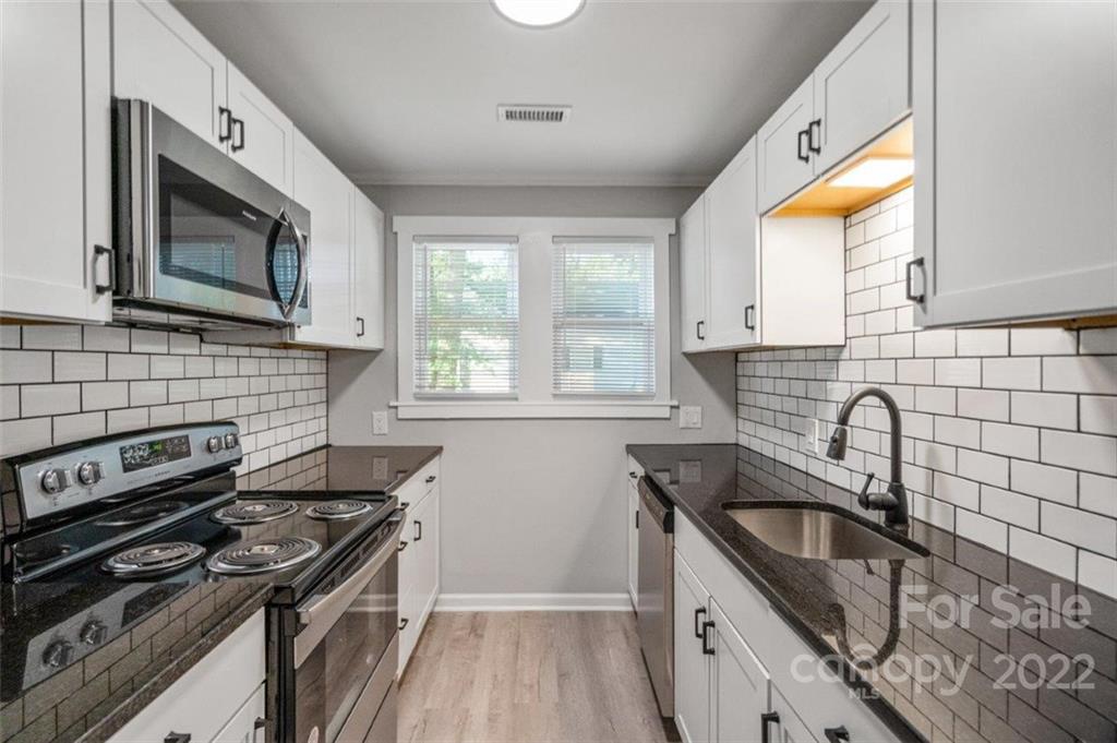 413 Modena Street Gastonia, NC 28054 - Photo 18 of 22 a kitchen with granite countertop cabinets stainless steel appliances a sink and a window