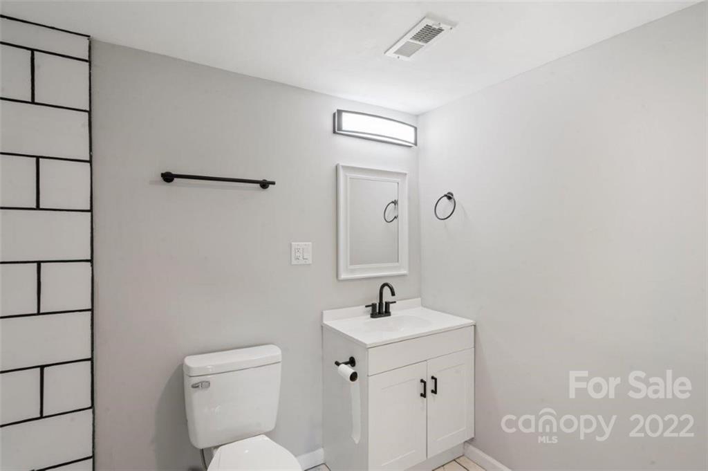 413 Modena Street Gastonia, NC 28054 - Photo 19 of 22 a bathroom with a toilet sink and mirror