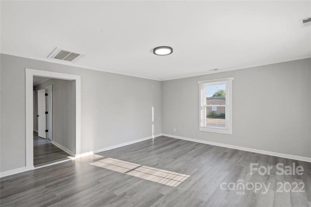 413 Modena Street Gastonia, NC 28054 - Photo 7 of 22 an empty room with wooden floor and windows