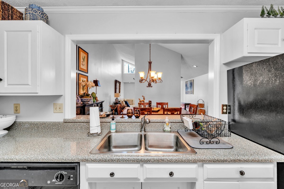 254 Valhalla Road South, Unit F Cordele, GA 31015 - Photo 13 of 41 a kitchen with kitchen island granite countertop a sink a stove and cabinets