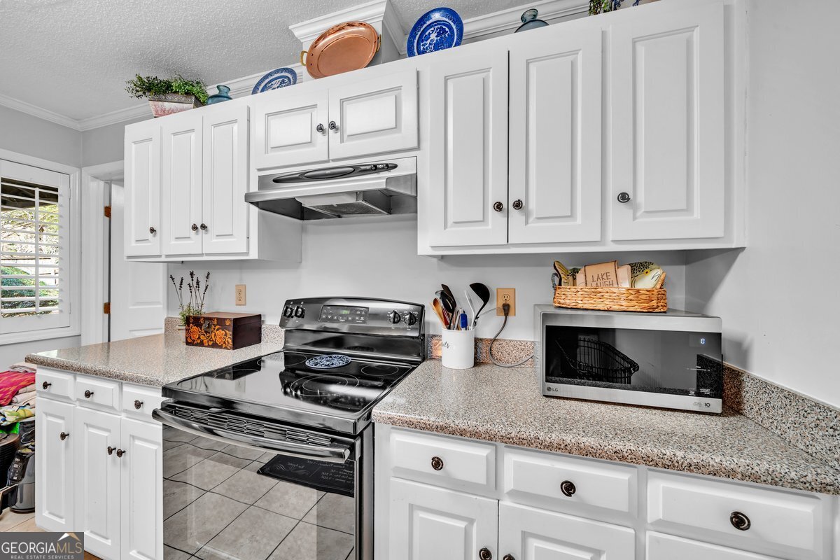 254 Valhalla Road South, Unit F Cordele, GA 31015 - Photo 14 of 41 a kitchen with granite countertop white cabinets and white appliances