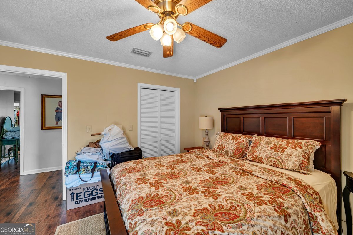 254 Valhalla Road South, Unit F Cordele, GA 31015 - Photo 26 of 41 a bedroom with a bed and wooden floor