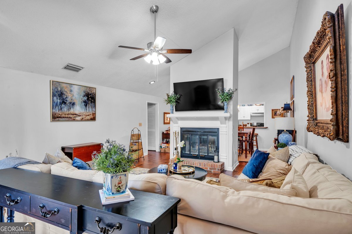 254 Valhalla Road South, Unit F Cordele, GA 31015 - Photo 7 of 41 a living room with furniture a fireplace and a flat screen tv