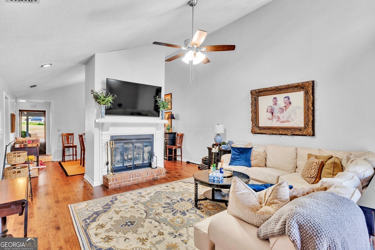 254 Valhalla Road South, Unit F Cordele, GA 31015 - Photo 8 of 41 a living room with furniture a fireplace and a flat screen tv
