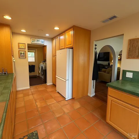 a kitchen with stainless steel appliances granite countertop a refrigerator and a stove
