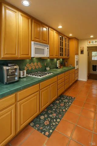 a large kitchen with stainless steel appliances a large counter top sink and cabinets