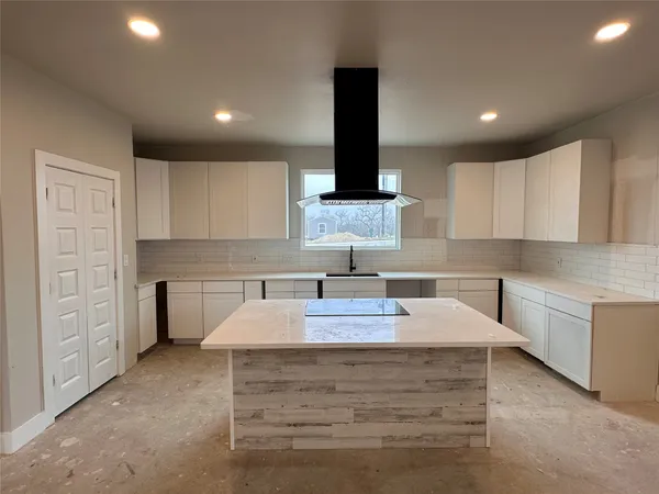 a kitchen with kitchen island granite countertop a sink stainless steel appliances and cabinets