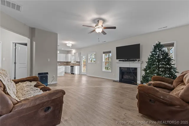 a living room with furniture a fireplace and a flat screen tv
