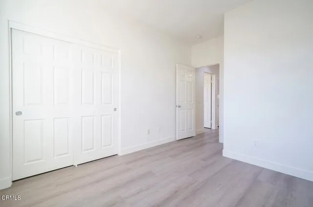 a view of an empty room with wooden floor