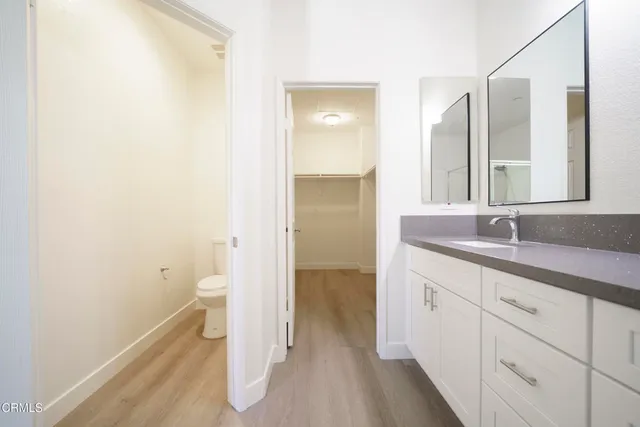 a bathroom with a sink and mirror with toilet
