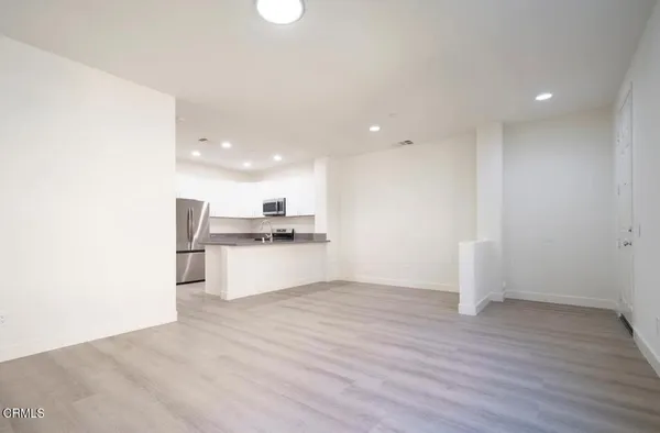 a view of kitchen with kitchen island white cabinets and wooden floor