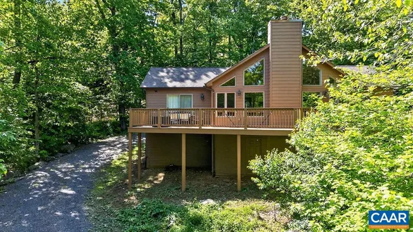 a view of house with a yard and sitting area